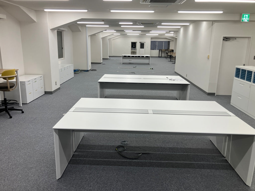 白いベンチデスクを並べた執務フロア
